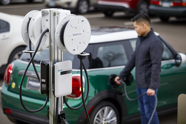An electric vehical is charging, with the text, Clean BC, our nature, our value, our future. Clean BC Go Electric, EV charging Rebate Program.